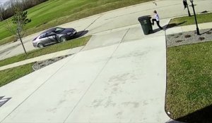 un enfant se bat contre le vent avec une poubelle