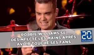 Robbie Williams se désinfecte les mains après avoir touché ses fans