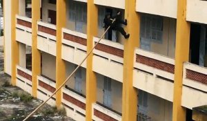 La police vietnamienne a une technique unique pour escalader les murs avec un bambou