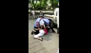 Un policier chinois jette au sol une maman et son bébé... Dingue