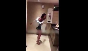 Une fille ivre s’amuse à faire du hula-hop avec la cuvette des toilettes