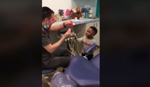 Un dentiste fait de la magie à un enfant