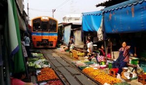 Ce marché en Thailande est installé au milieu d'une voie ferrée... Incroyable