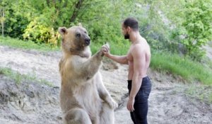 Belle amitié entre un gros ours et son maitre