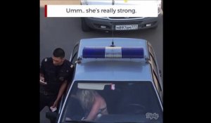 Regardez comment elle va essayer de sortir de la voiture de police