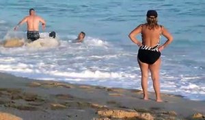 Il essayent de sortir une femme des courants des vagues à la plage !