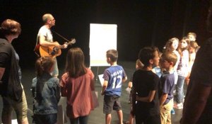 Le chanteur Mazarin fait répéter les enfants des forains avant le concert de comptines ce vendredi