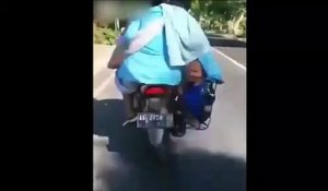 Ces parents transportent leur enfant dans le porte bagage de leur moto... Pure folie