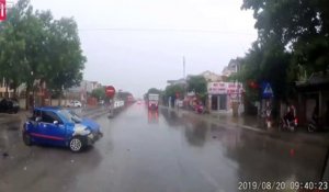 2 camions jouent au foot avec une voiture dans la rue..