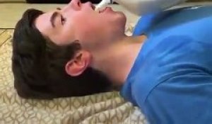 Il laisse son chien boire du lait dans sa bouche