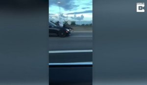Ce conducteur croises un homme couché sur le capot d'une voiture sur l'autoroute
