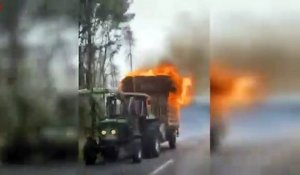 Ce tracteur roule tranquillement sur la route avec sa remorque en feu