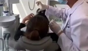 Une patiente de dentiste tente de faire un cœur avec sa main et son dentiste