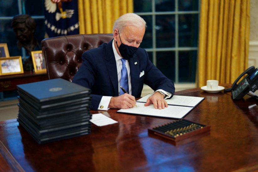 Joe Biden signe les &quot;executive orders&quot; lors de ses premières minutes dans le Bureau ovale de la Maison-Blanche à Washington, le 20 janvier 2021.