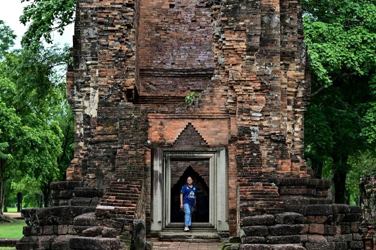 L'archéologue thaïlandaise Tanachaya Tiandee pose devant un des monuments de la vieille cité de Si Thep, qui postule mardi au vote à l'Unesco pour être inscrit sur la liste du patrimoine mondial, le 14 septembre 2023