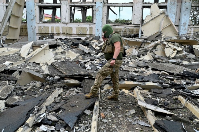 Un membre des forces ukrainiennes dans les décombres de l'Institut polytechnique de Kharkiv touché par plusieurs missiles, le 24 juin 2022 dans le nord de l'Ukraine